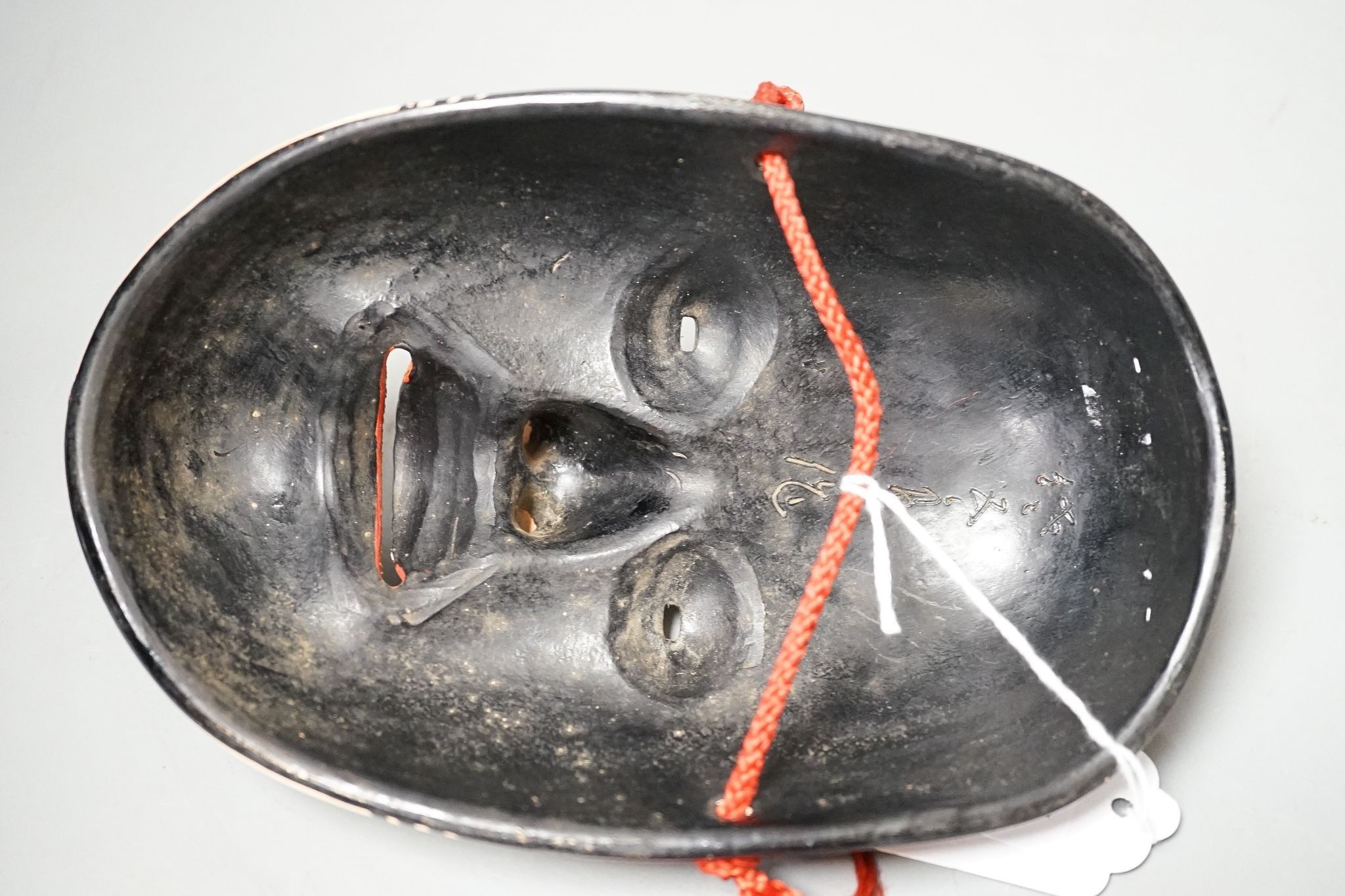 A Japanese pottery Okame noh mask, early 20th century, signed, 19.5 cms high.
